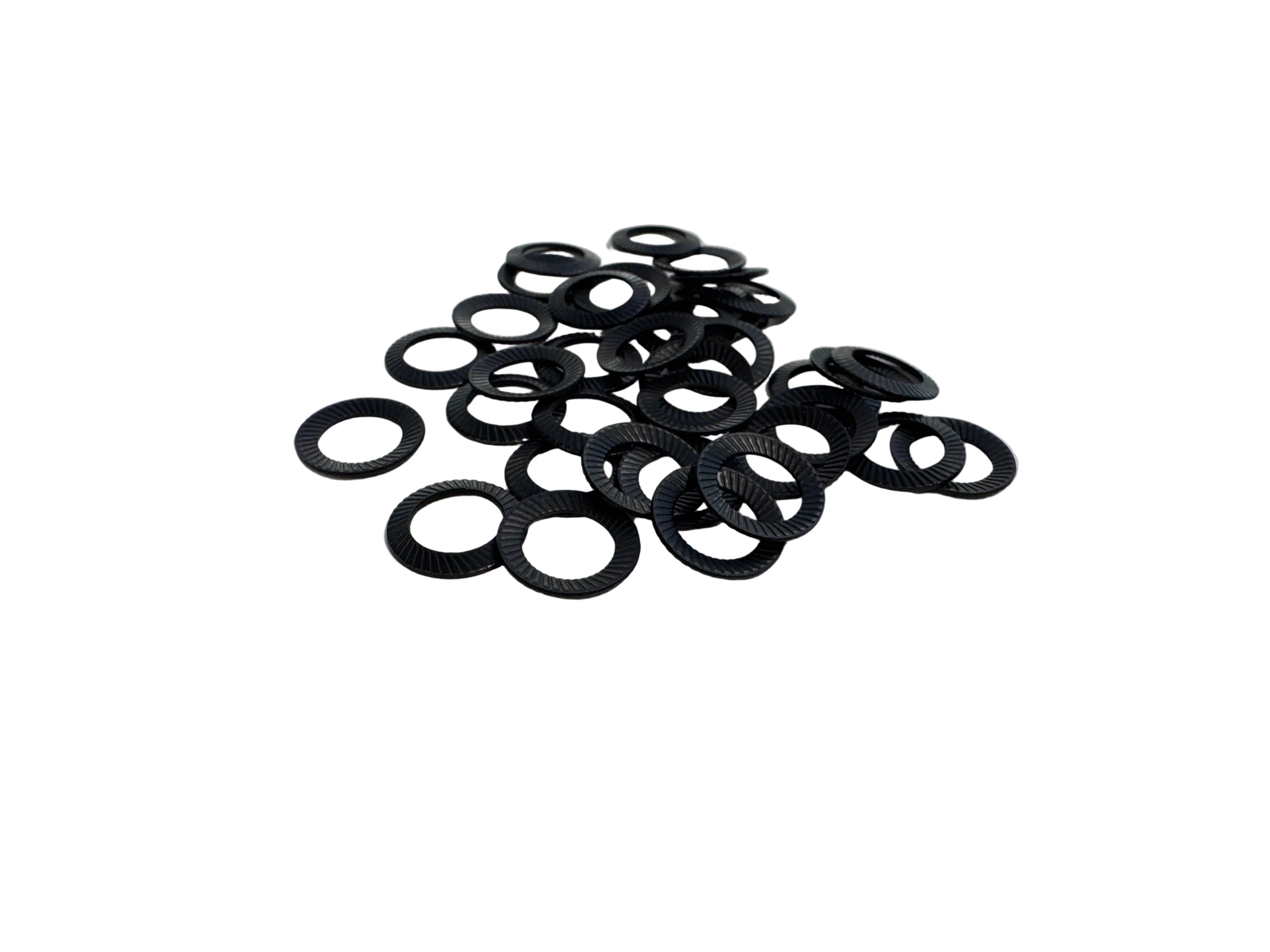 A pile of small black textured ring-shaped washers or grommets on a plain light gray surface.