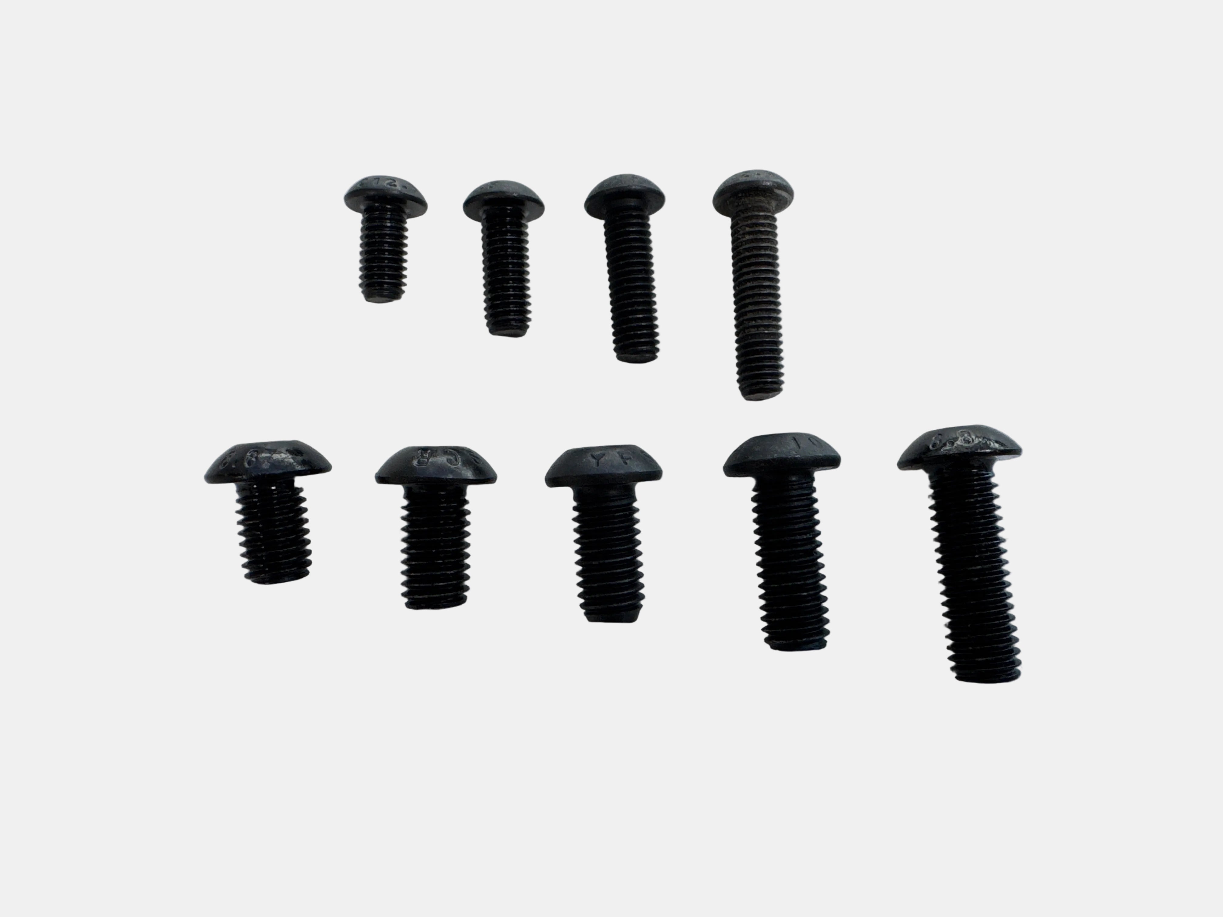 Eight black flat-head screws arranged in two rows on a plain light background.