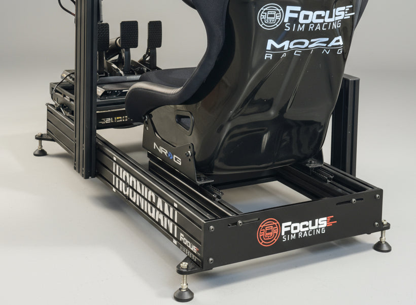 Simulator racing seat with 'Focus Sim Racing' and 'Moza Racing' branding on a stand.